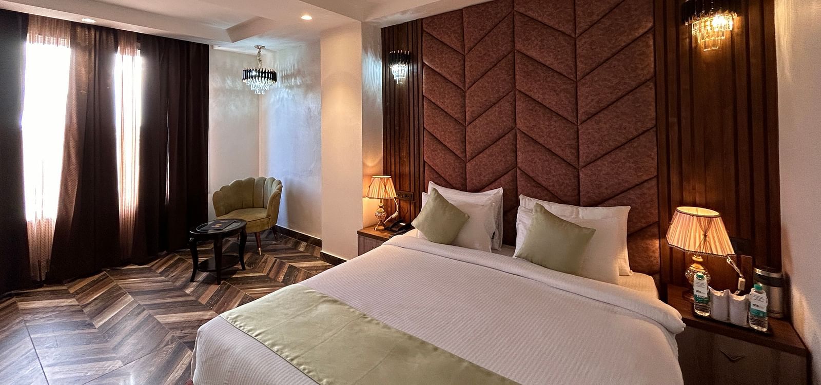 Image of Super Deluxe Room featuring a double bed with a nightstand next to it  as the sunlight makes its way into the room through the curtains - DLS Grand Luxotica, Dehradun