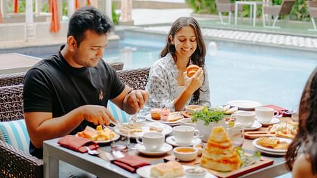 A couple enjoying their breakfast beside the pool area at Crescent Spa & Resort, Indore