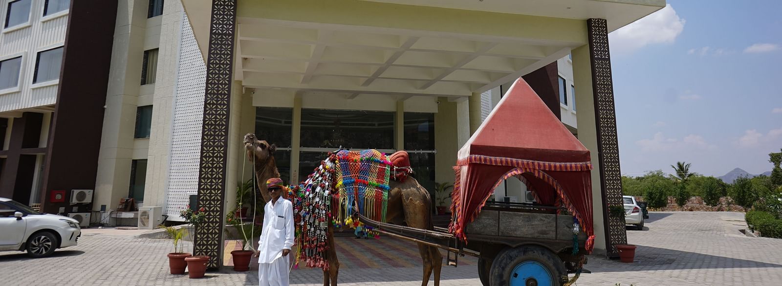 Exterior view of Bamboo Saa Mulberry Resort, Pushkar, Rajasthan, showing the main entrance and a  horse-drawn carriage in the foreground.
