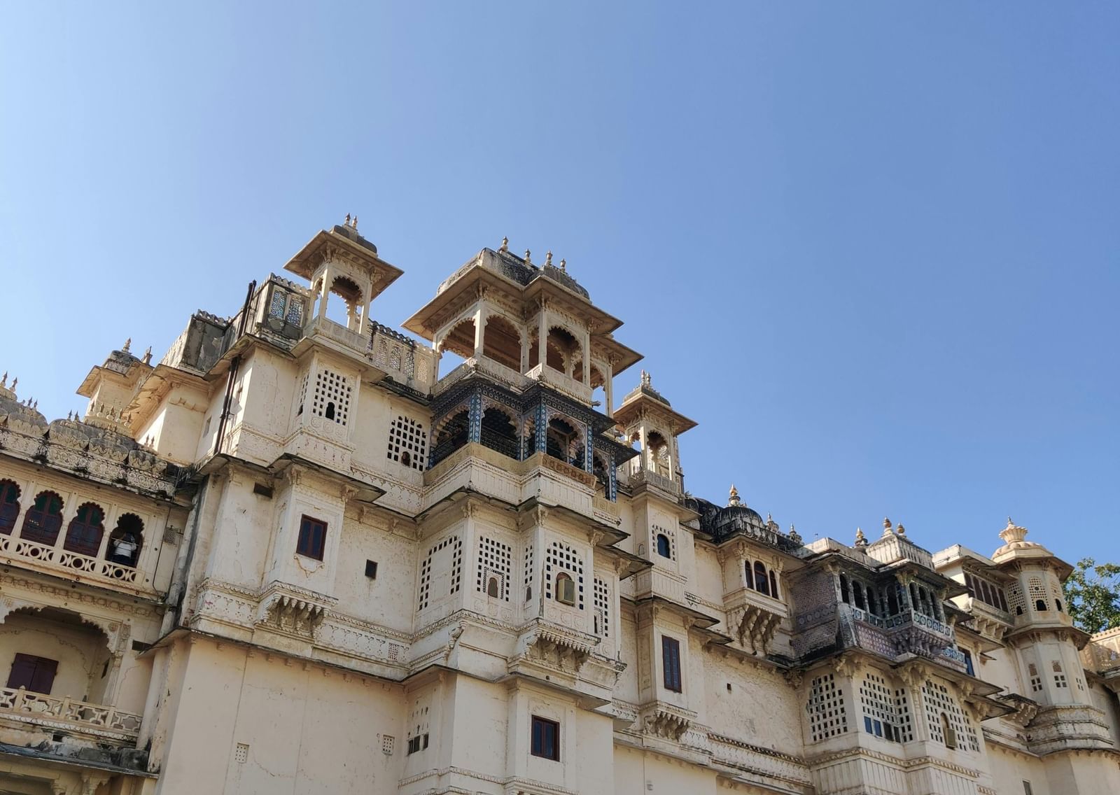 Front view of a grand palace in Udaipur under a clear blue sky.