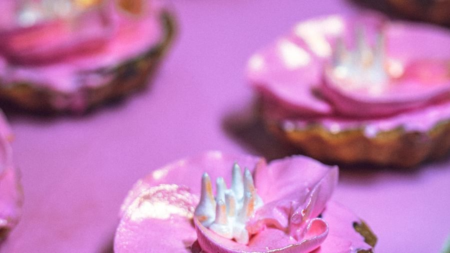 Small, round desserts with light-colored frosting, arranged on a surface.