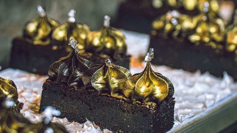A display of small, dark-colored desserts or chocolates on a tiered stand.