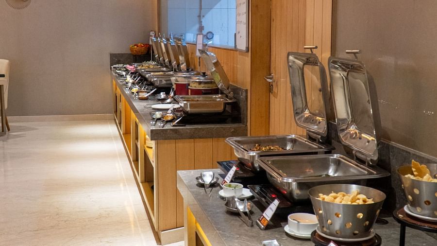A buffet line with different food items and serving utensils.