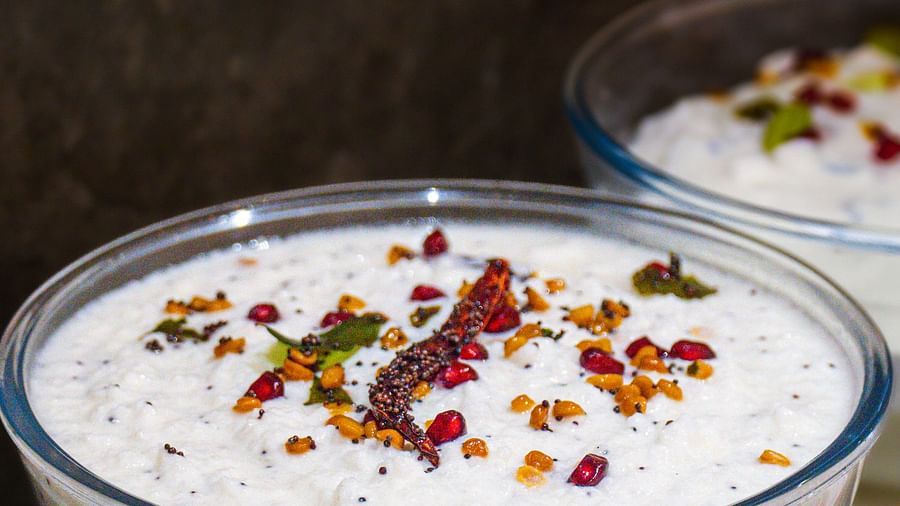 A glass bowl filled with a creamy dish, possibly yogurt-based, with garnish on top.