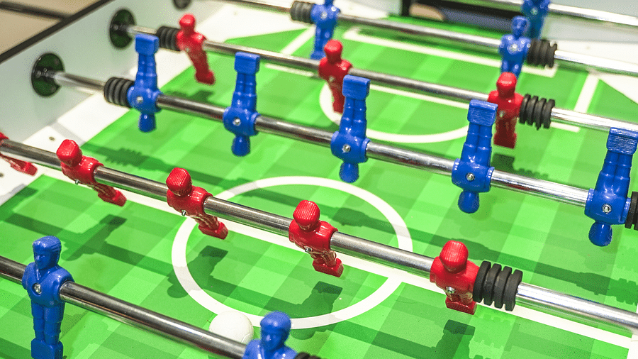 Foosball table featuring red and blue players in action, with the ball in play - Shervani Pebbles & Pines, Corbett