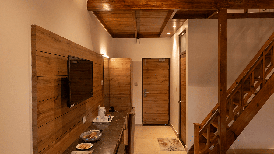 View from the entrance of a duplex suite showing the long console desk and wooden staircase leading to the upper loft - Wood Castle Spa & Resort, Jim Corbett