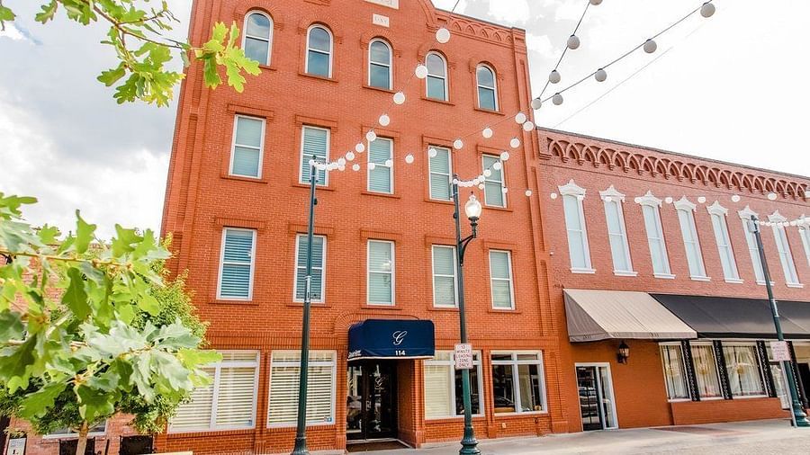  A photograph of a red-brick building with a modern design and charming architectural features, representing a historical landmark.