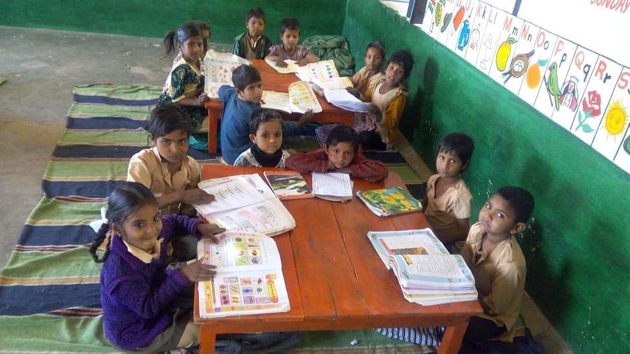 image of school kids reading books at a table in a government