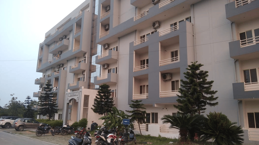 Front facade of a  Livbox, Rudrapur with parked bikes and greenery.