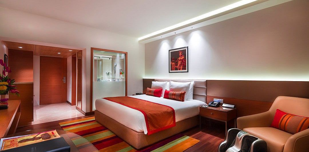 Grand Club Room with king size bed and sofa chair at Grand Chennai By GRT Hotels.