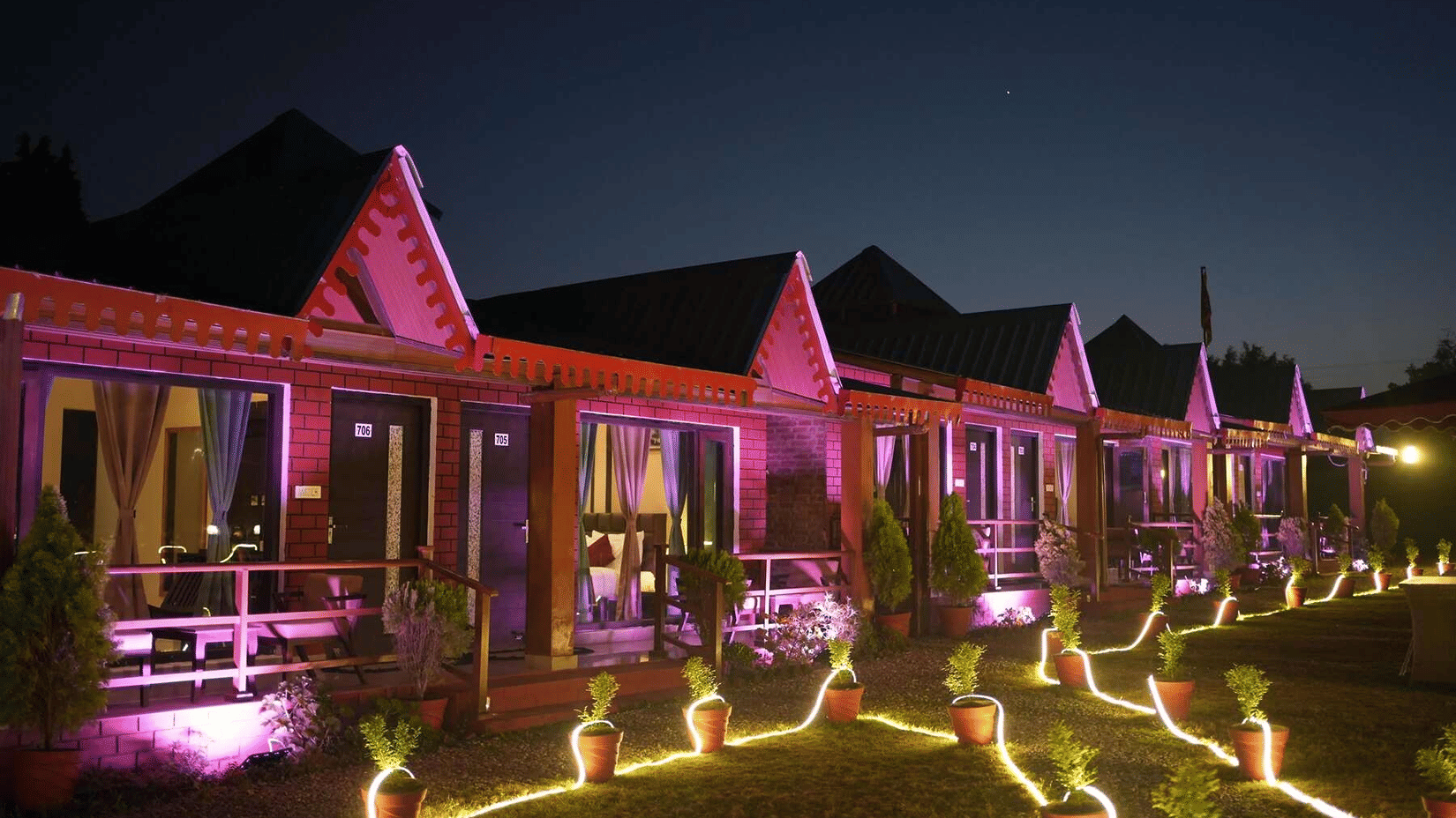 Sol Glow Resort cottages lit up at night with garden lighting near Bhowali, Nainital.