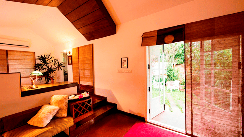 Living room with a red rug, comfy seating, and glass doors opening to the outside.