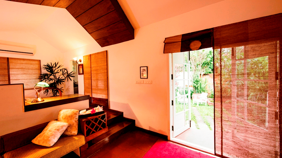 Living room with a red rug, comfy seating, and glass doors opening to the outside.