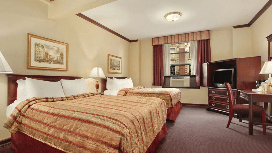 Spacious room with two beds, a work desk and modern artwork