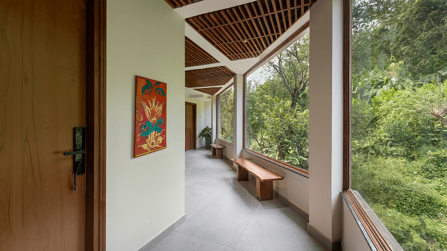 A corridor leading to the rooms with serene views of lush green trees on the side - The Samai, Bhimtal
