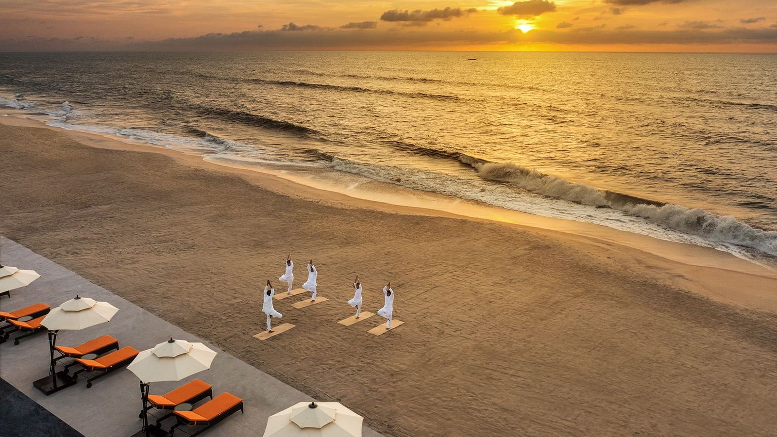 A yoga session on the shores of the bay of Bengal with a sky coated in orange from the rising sun - Kaldan Samudhra Palace, Mahabalipuram