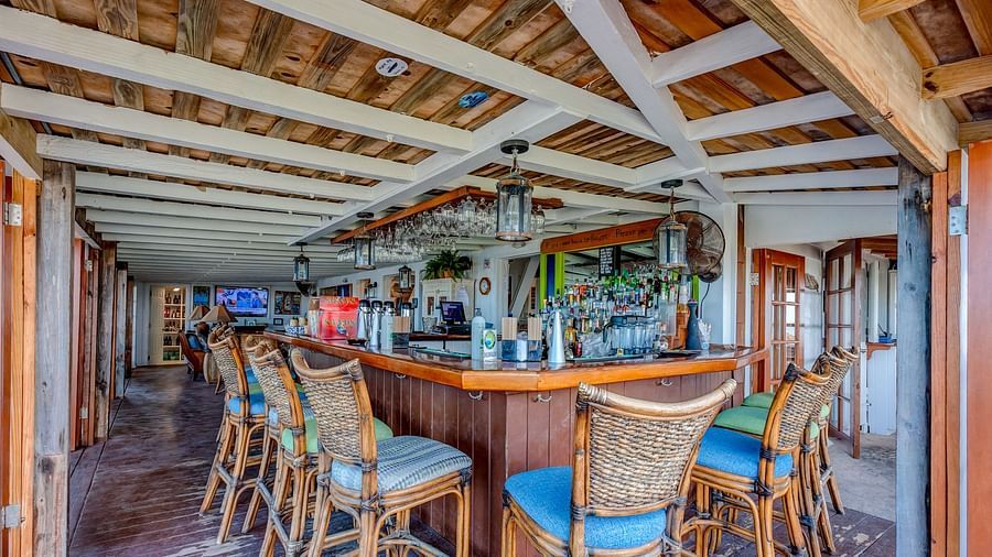 Bar counter with high chairs and wooden ceiling inside the dining area | Abaco Inn