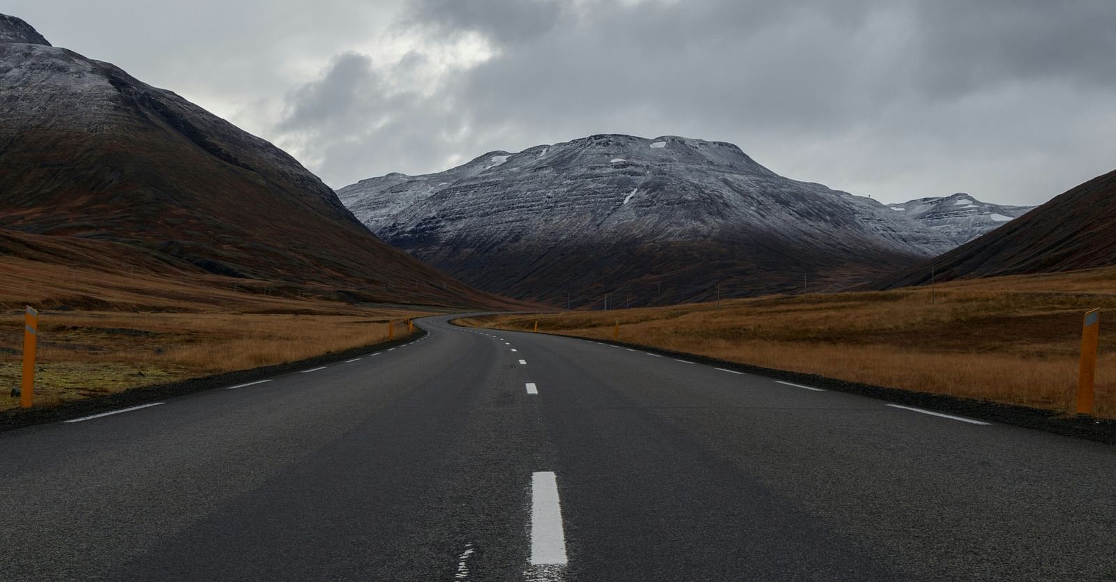 An overview of a highway with single lanes on either side and a mountain in the background.