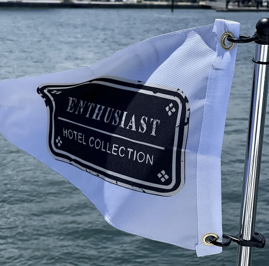 A close-up shot of a white flag with the logo of 'Enthusiast Hotel Collection'.