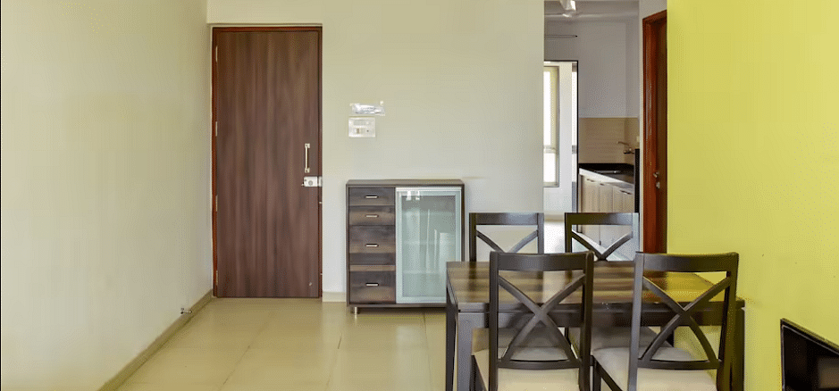 Dining area with a table and chairs, a door way leading to another room at La Vida Studio Inn Goa.