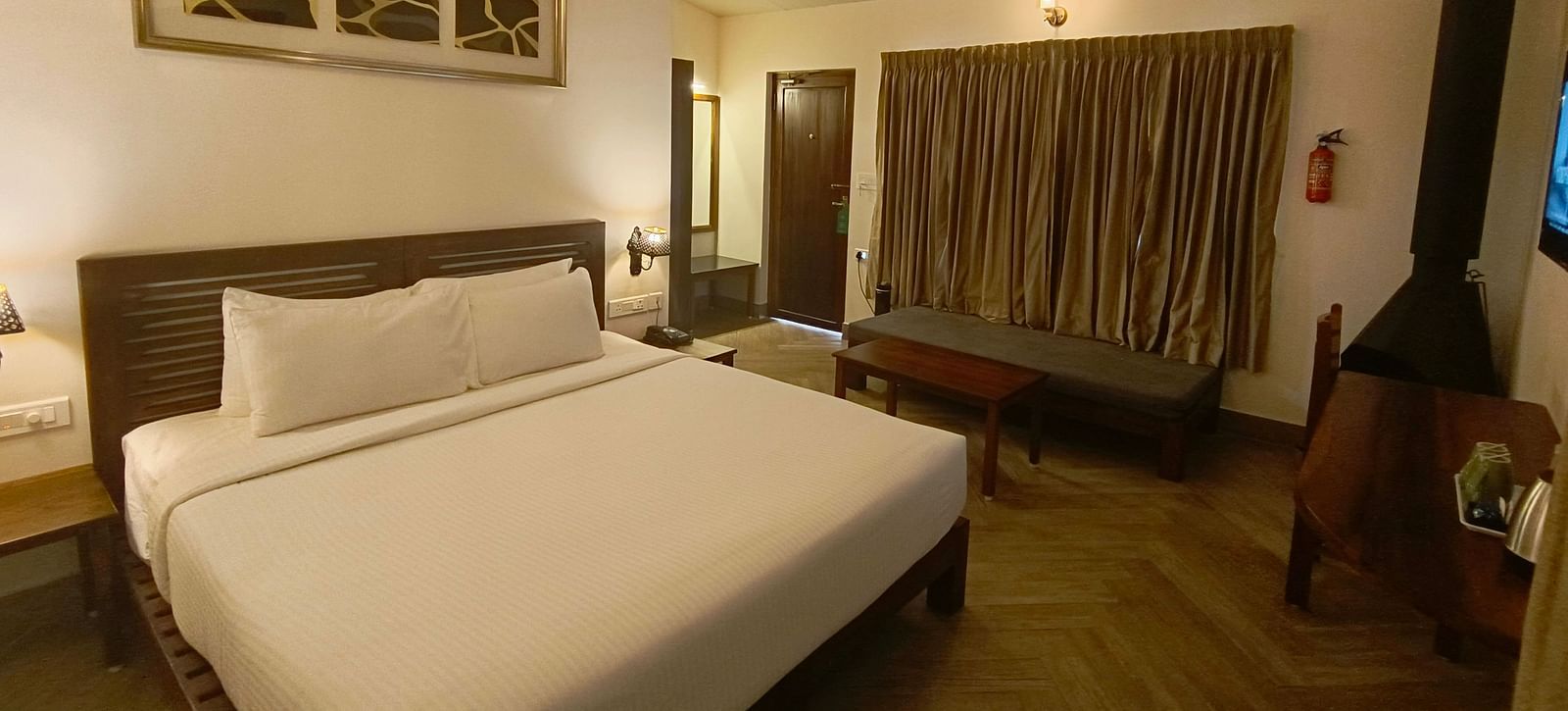Classic room with a queen-size bed, cozy seating area, and warm lighting.