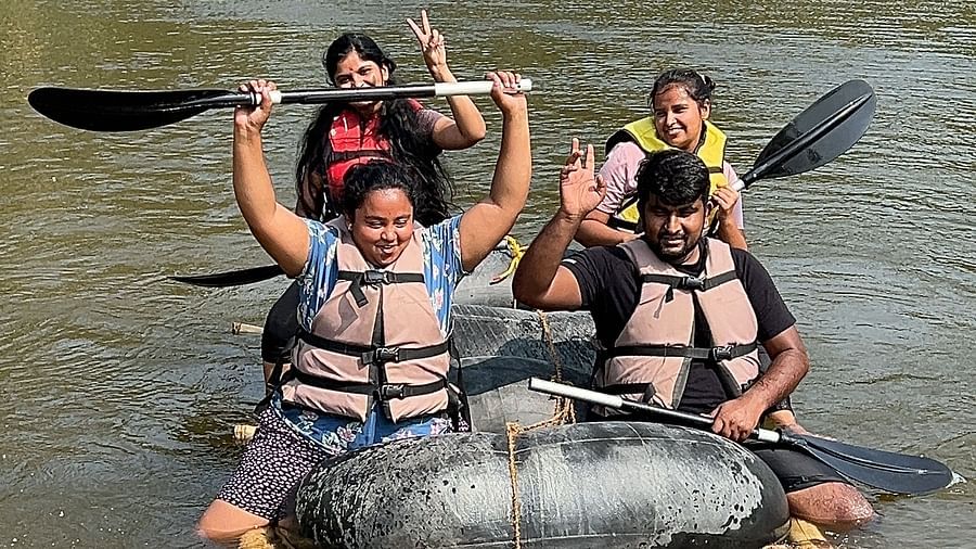 A group of people enjoying bamboo rafting on a calm river surrounded by lush greenery - Evergreen County