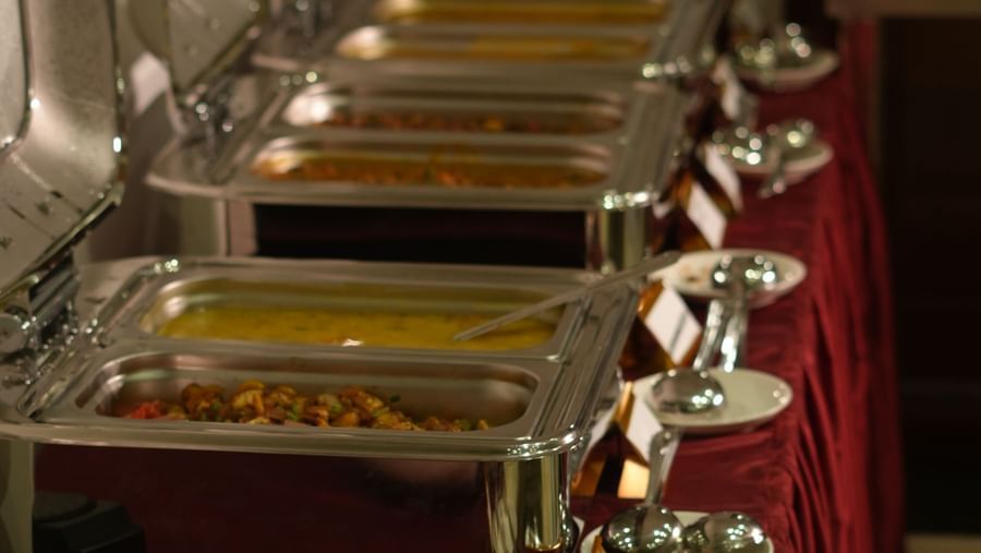 A close-up shot of the buffet counter in the restaurant featuring chafing dishes at WOW Naturefull Resorts.