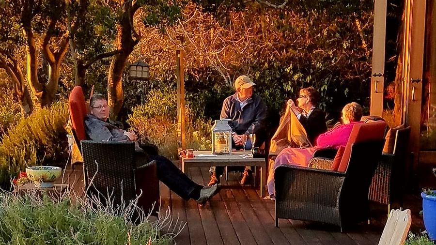 A serene deck with seating, surrounded by trees at sunset - Brewery Gulch Inn & Spa