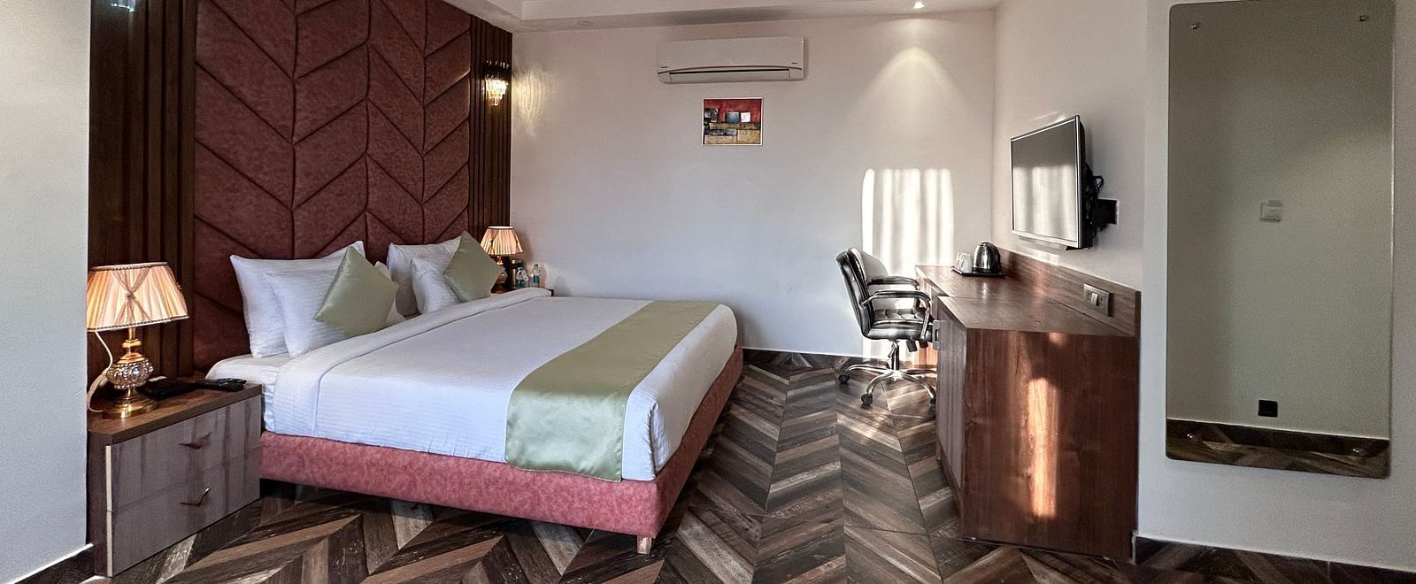 A shot of a the premium room featuring a bed, flat screen TV, bed side tables on which lamp shades are placed - DLS Grand Luxotica, Dehradun