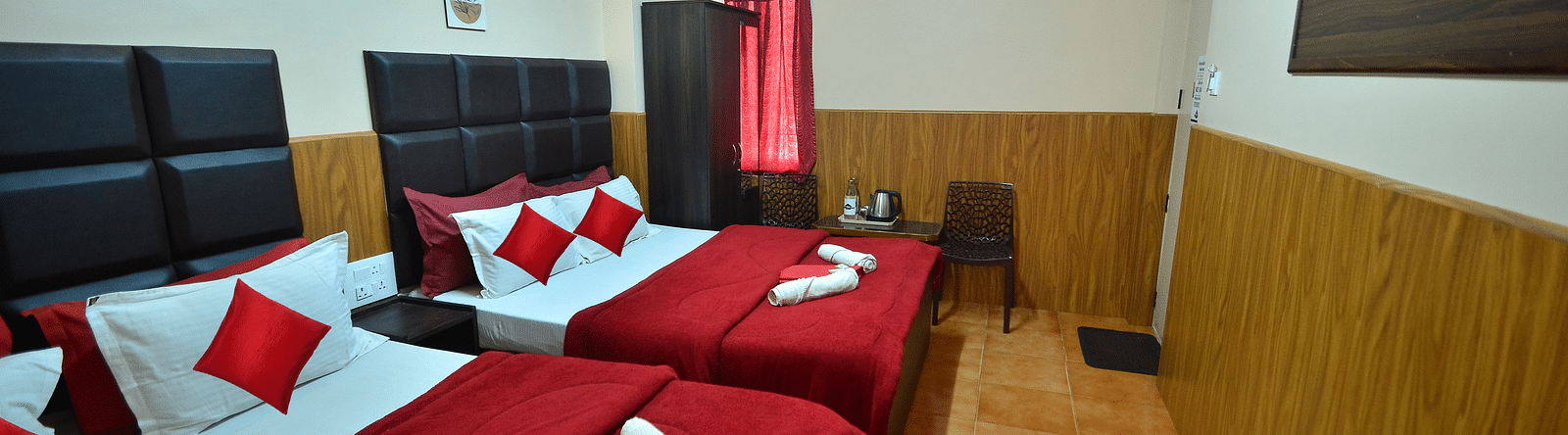 Image of two double beds and a television in front at BN Tourist Home.