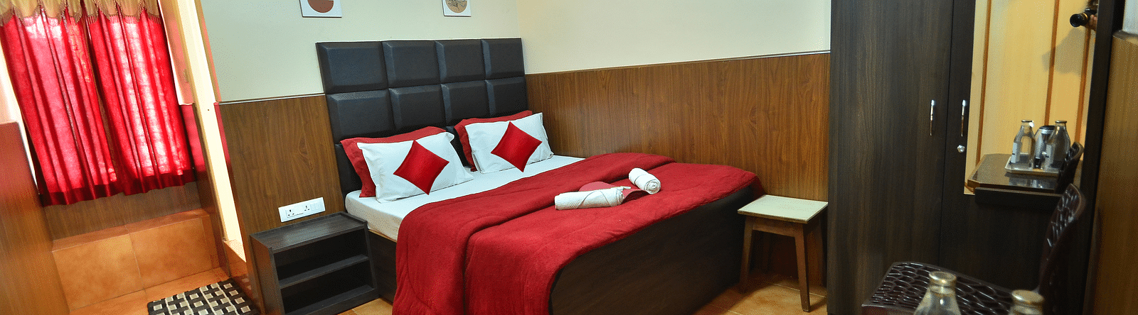 Image of a room with a bed, wardrobe, electric kettle and water bottle at BN Tourist Home, Ooty