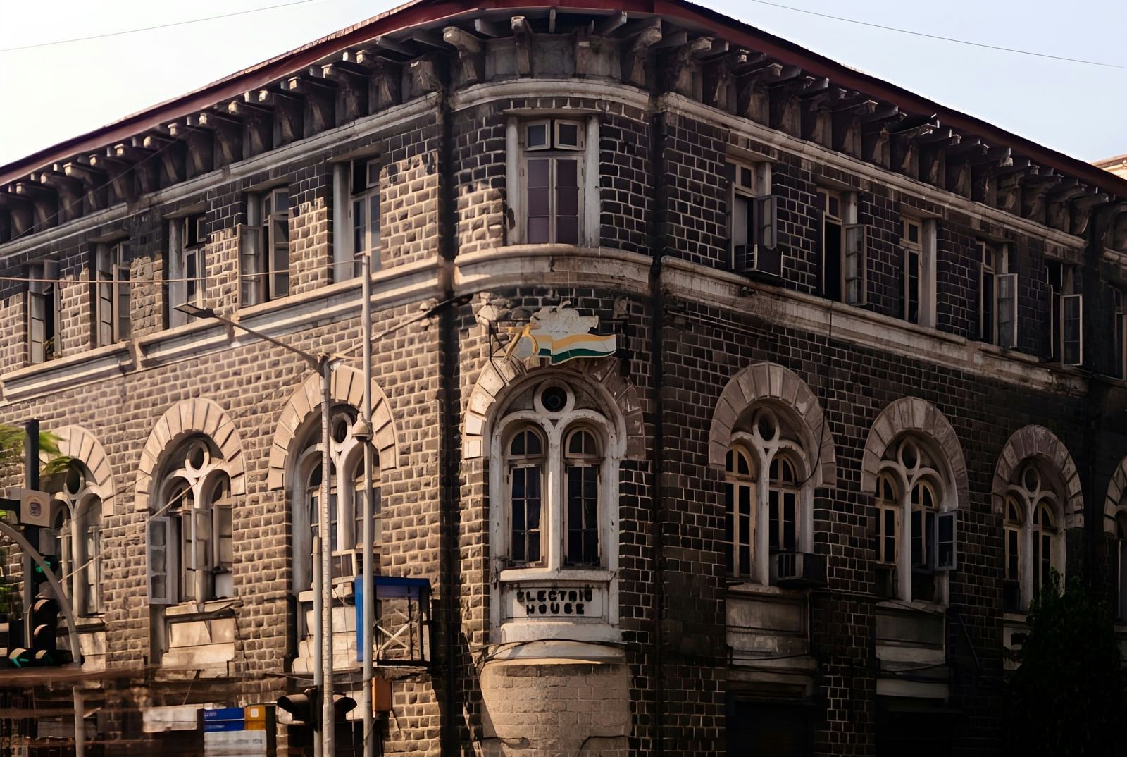 A large, historic building with distinctive architecture and blurred traffic moving in front of it.
