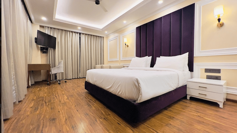 Claret Inn, Dalhousie - Rooms with balcony in Dalhousie with a bed, wooden flooring, dark curtains, wall lights, and a mounted TV.