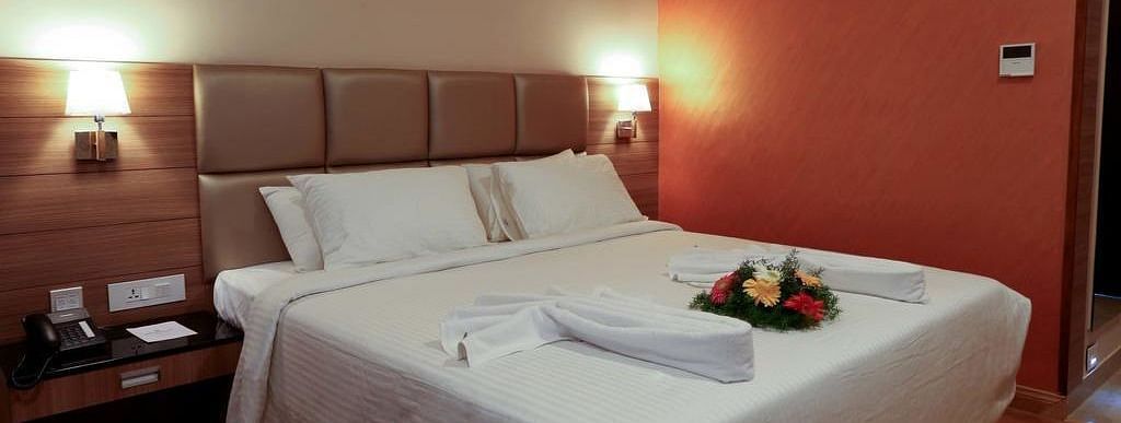 Close up view of room with flower arranged on the bed wit a side table at Fressotel Seetharam, Coimbatore