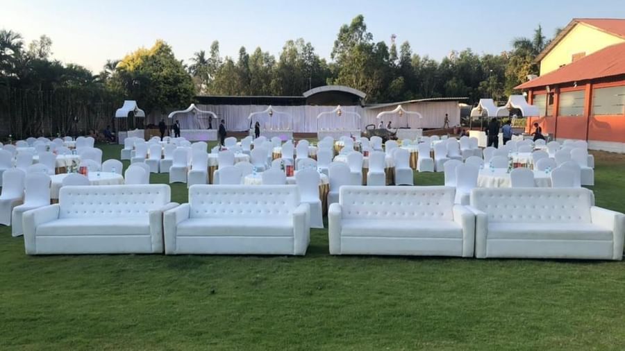 White sofa seating setup on the lawn for an outdoor event at Ilara Hotels & Spa, OMR, Chennai