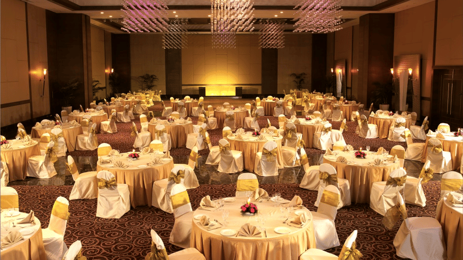 A banquet hall with round linen-covered tables set for a formal event at The Retreat Hotel and Convention Centre.