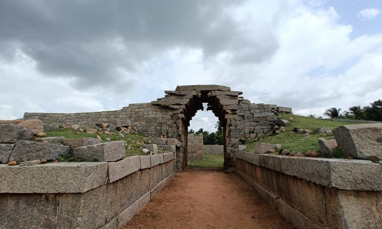 Stone archway of Bhima's Gate amidst ruins in Hampi.