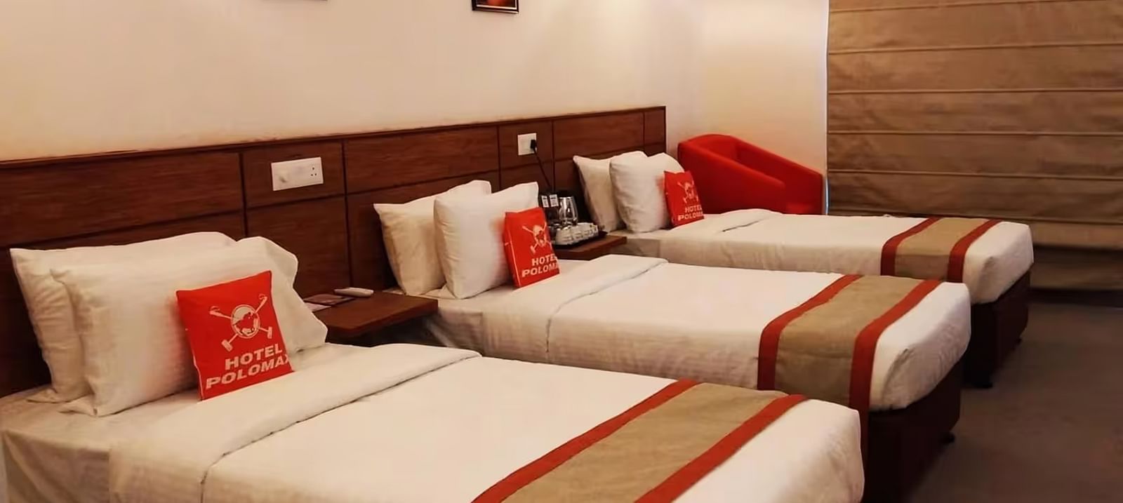 View of a Hotel room with three beds arranged, bedding, and a modern design in Max Club Room - Max Hotel Prayagraj.