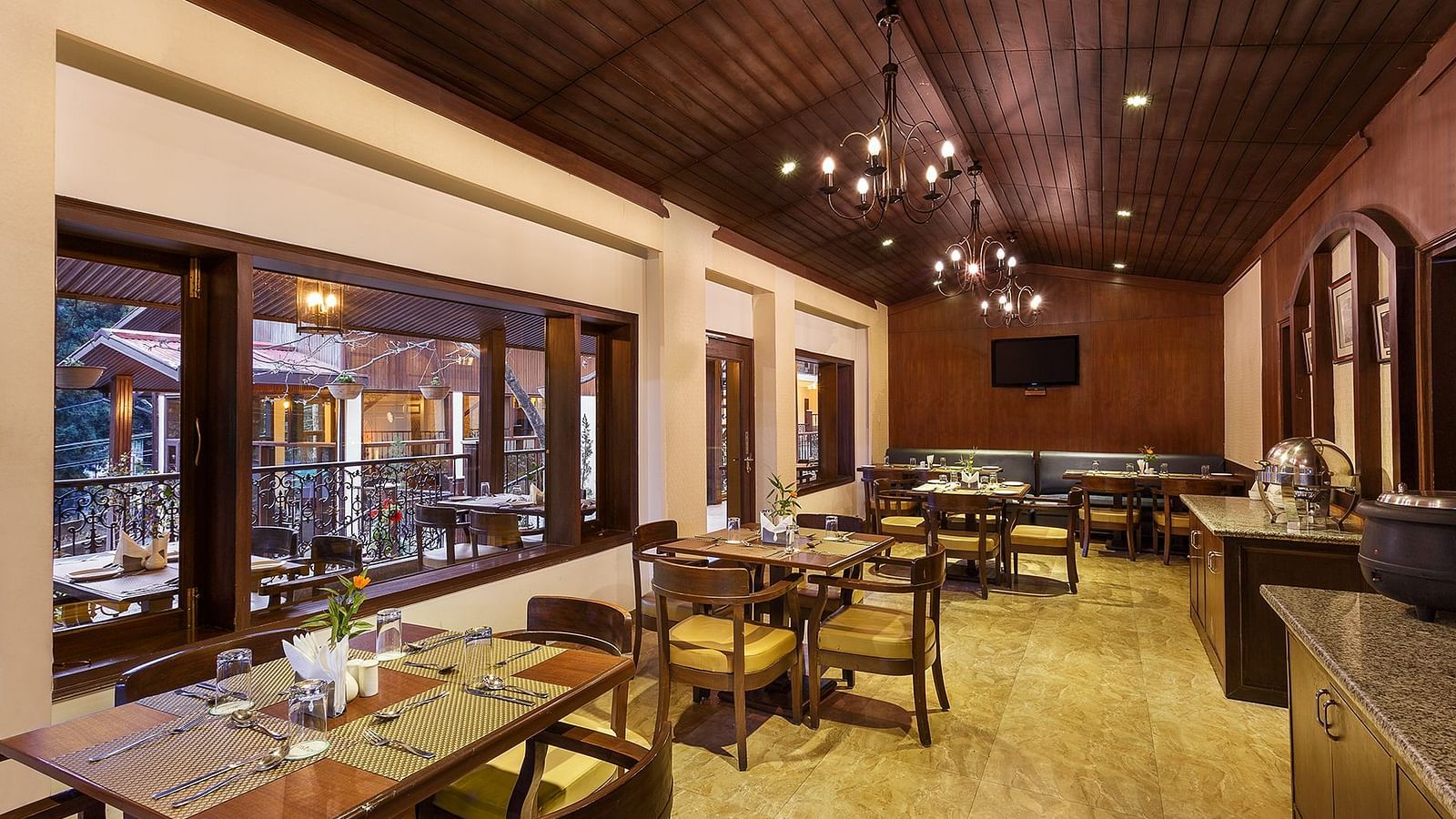 an indoor dining setup with tables lined up on one side and a buffet setup on the other side - The Earl's Court, Nainital