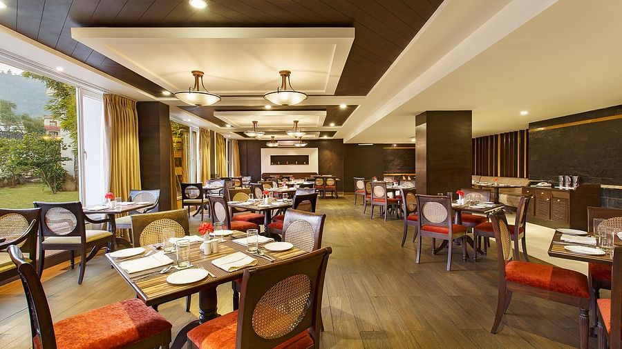 Latitude - A multi-cuisine restaurant in Rishikesh with tables and chairs in clusters spread across the space - Aloha On The Ganges, Rishikesh