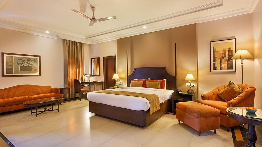 Maharaja Suite with two sofas and a large bed in the middle with standing lamps - Ganga Lahari, Haridwar