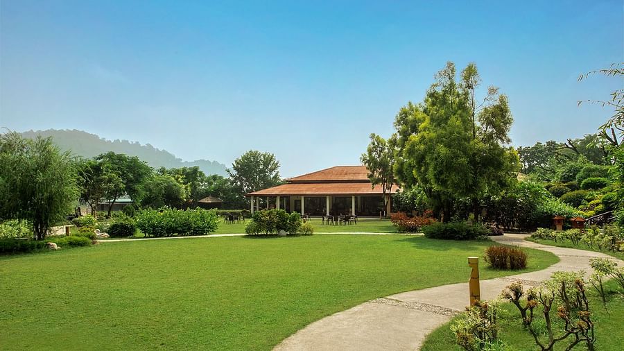 An image of a huge lawn with trees and in one corner there is a cottage - The Riverview Retreat, Corbett