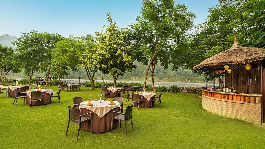 An image of a seating arrangement in a lawn near a hut - The Riverview Retreat,  Corbett