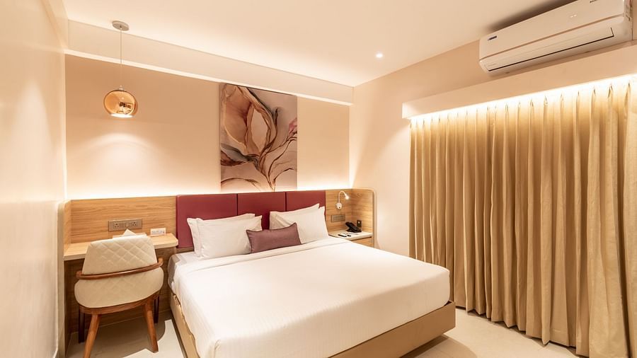 Bedroom with large windows in The Executive Room at Livancia The Sojourn, Bangalore.