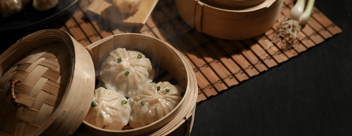 Momos served in a traditional bamboo steamer box.