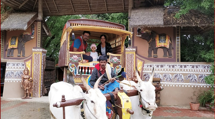 image of a family enjoying the bullock cart ride experience at hoysala village resort in hassan