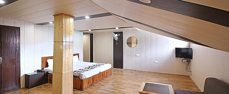 A room at DLS Hotel Devlok, Manali with a sloping roof line and a double bed