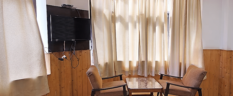 A room at DLS Hotel Devlok, Manali with a coffee table arrangement placed besides a window
