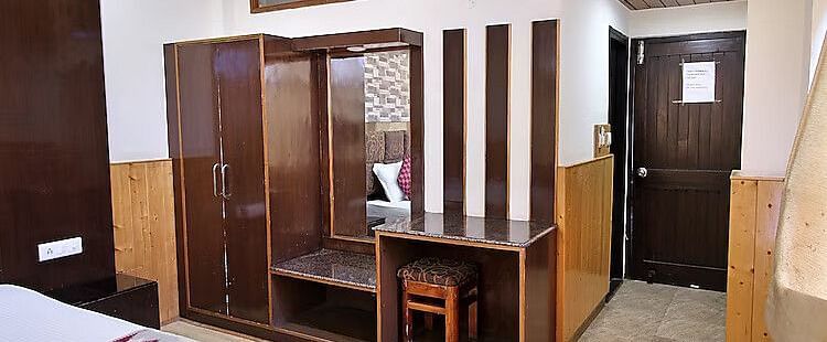 A view of the wardrobe and dressing mirror set up in a room at DLS Hotel Devlok, Manali