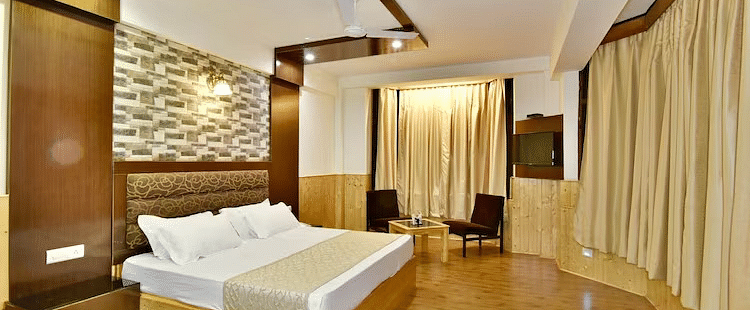 A room at DLS Hotel Devlok, Manali with a double bed, a coffee table set up and wooden flooring